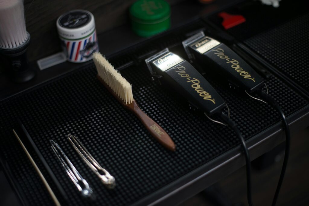 Close-up of hair clippers and grooming tools in a modern barbershop setup.
